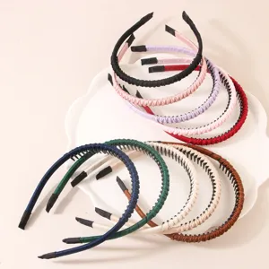 Primo piano di cerchietti sottili assortiti con denti antiscivolo su un vassoio bianco.