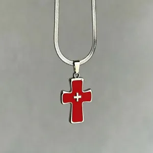 Primer plano de collar gótico punk de plata con colgante de cruz de esmalte rojo
