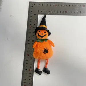 Vue détaillée d'un ornement de poupée sorcière d'Halloween en peluche orange avec une règle