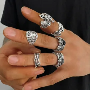 Close-up detail of silver punk gothic rings with skull and bat wing motifs