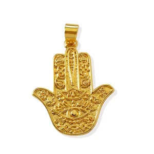 Close-up detail of gold Hamsa hand pendant, intricate engraved patterns, 18K brass jewelry accessory.