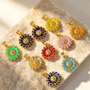 Close-up detail shot of colorful enamel sunflower pendants featuring shiny gold-plated metal.