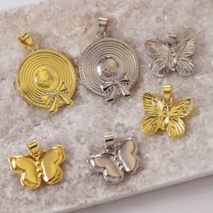 Nahaufnahme von Gold und Silber Messing Sonnenhut und Schmetterling Anhänger für DIY Schmuck.
