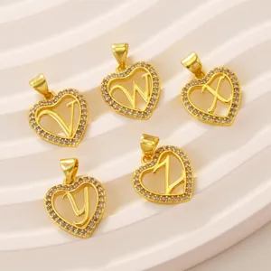 Close-up of 18k gold plated brass heart letter pendants set with sparkling pavé stones.
