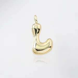 Close-up detail of a cute puffy gold letter L pendant, glossy smooth metal finish accessory.
