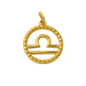 Close-up detail of a gold-plated brass Libra zodiac sign pendant with beaded rim design.