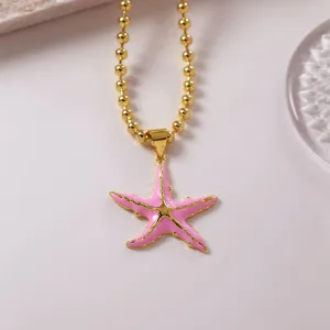 Collana con catena a sfere dorata e ciondolo a stella marina smaltata rosa in stile dolce.
