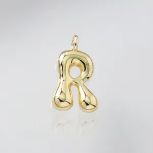 Close-up detail shot of a cute puffy shiny gold bubble letter R pendant jewelry.