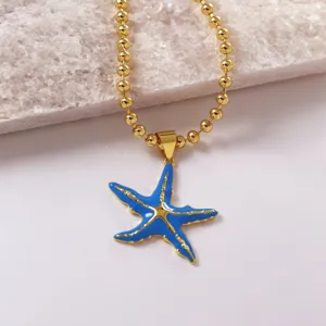 Collana con catenina di perline dorate e ciondolo a stella Marina in smalto blu, chic.