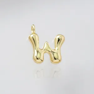 Gold puffy letter W pendant close-up, shiny metallic texture charm for DIY jewelry making