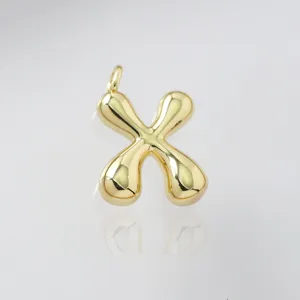 Detailed view of a cute chubby golden bubble letter X pendant, glossy surface finish design.
