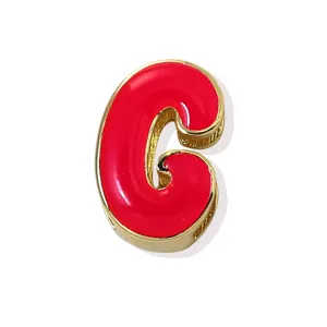Gold-plated red enamel letter C pendant detail shot, stylish shiny DIY jewelry accessory.