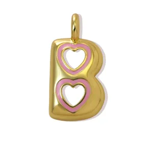 Dettaglio del ciondolo con lettera B placcato in oro con smalto a cuore rosa per collana fai da te.