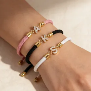 Primo piano dettagliato di bracciali con corda intrecciata regolabile e ciondoli in zircone.