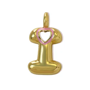 Primo piano dettagliato del ciondolo a lettera placcato oro con un grazioso cuore smaltato rosa.