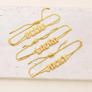 Gepersonaliseerde vergulde armbanden met bubbelletter bedels detail aangepaste namen.