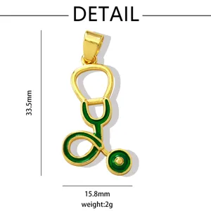 Close-up detail shot of a gold stethoscope pendant with green enamel and clear dimension markings.