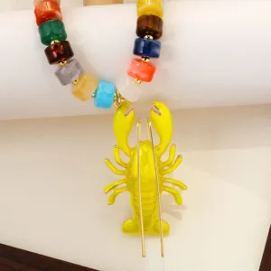 Détail du collier pendentif homard en perles acryliques colorées, style vacances plage bohème.