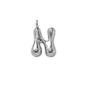 Close-up detail of silver puffy letter N pendant, smooth metallic surface, elegant.