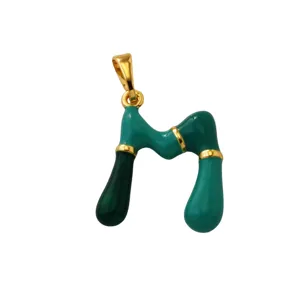 Detail view of the green enamel letter M pendant, featuring 18k gold plated brass design.