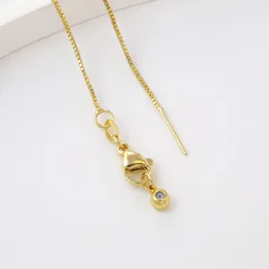 Gold box chain necklace detail view with lobster clasp and extension component.