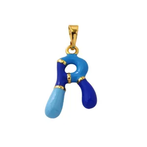 Close-up detail of a blue enamel letter R pendant with 18K gold plated brass. Jewelry macro shot.