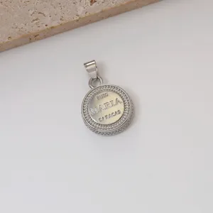 Detail van zilveren ronde hanger met MARIA lettergravure en delicate strass steentjes.
