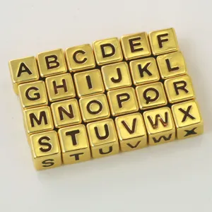 Close-up of square gold alphabet beads for DIY jewelry making and custom name bracelets.
