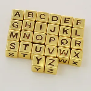 Gold alphabet cube beads detail shot, A to Z letter charms for DIY jewelry making and bracelets.