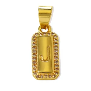 Dettaglio del ciondolo con lettera J rettangolare dorata, bordo in zirconi e accessorio per gioielli.