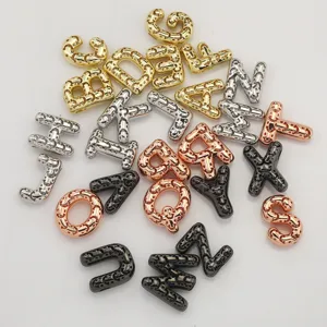 Breloques lettres en métal avec design de visage souriant creux pour bijoux DIY.