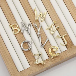 Close-up details of brass 26 alphabet letter charms, gold and silver DIY jewelry pendants.