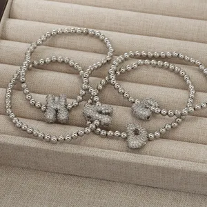 Klobiges, aufgeblasenes Buchstaben-Anhänger-Perlenarmband mit funkelnden Zirkonia-Details.