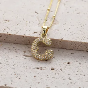 Détail de pendentif lettre C en or, oxydes de zirconium micro-sertis, chaîne fine chic.