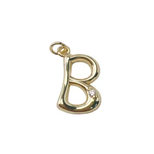 Close-up detail of a gold electroplated letter B pendant with sparkling crystal inlay.