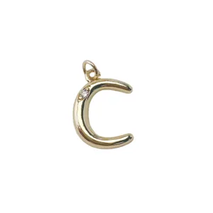 Close-up of gold-plated letter C pendant detail with sparkling embedded crystal stone.