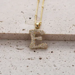 Vue détaillée du collier pendentif lettre E en cuivre plaqué or et zircone micro-serti.