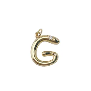 Detailed shot of the gold plated brass snake letter G pendant, exquisite metal texture.