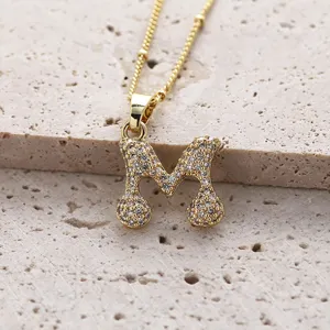 Collier pendentif lettre M en or avec pierres de zircone cubique étincelantes style élégant.