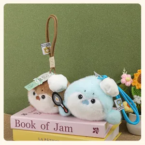 Cute sea otter plush keychain detail showing chef hat and mini pan doll pendant for girls bag