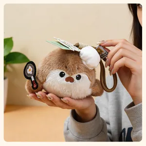 Cute plush otter bag charm detail, featuring a tiny chef hat and mini frying pan accessory.