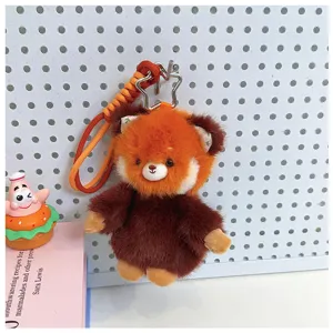 Simpatico portachiavi in peluche panda rosso con cinturino intrecciato per la tua borsa.