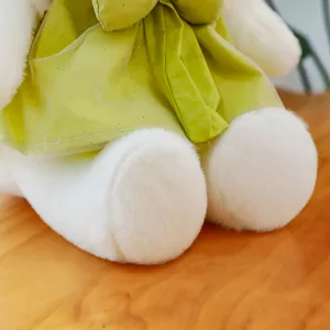Cute princess cat plush toy with green sparkly dress and bow, sitting soft stuffed animal doll.