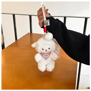 Cute scented sheep plush toy keychain detail, soft white fluffy animal pendant hanging on display.