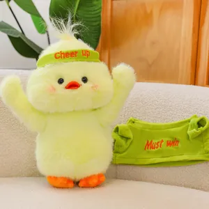 Cute yellow plush duck toy with green cheering outfit and headband, soft stuffed doll variant.