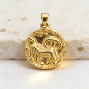 Close-up detail of vintage gold coin zodiac relief pendant, niche luxury gold-plated jewelry.