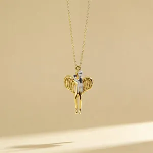 Close-up detail of the two-tone hugging angel wings pendant necklace, elegant metal craft.