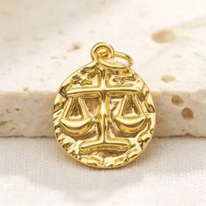 Close-up detail of vintage gold-plated zodiac coin pendant showing exquisite relief texture.