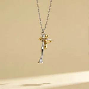 Detailed shot of the two-tone hugging couple pendant necklace, featuring minimalist silver-gold.