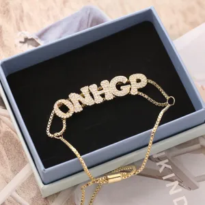 Gold letter ONHIGP zircon pendant bracelet detail view, delicate adjustable chain jewelry.